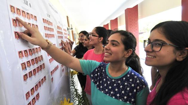 Students of Mount Carmel School checking their results at school notice board on Sunday. (Ravi Kumar/HT)