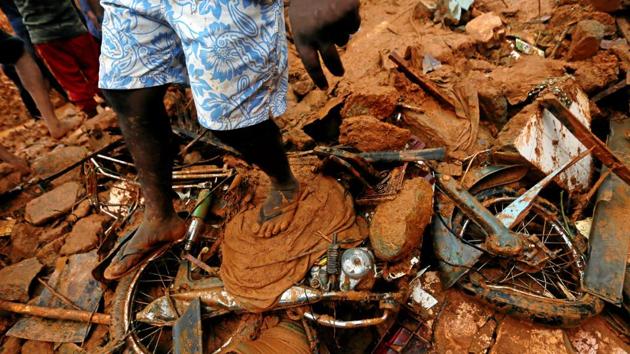 A man stands on top of a damaged bike during a rescue mission at the site of a landslide in Bellana village in Kalutara, Sri Lanka. (Dinuka Liyanawatte / REUTERS)