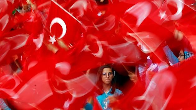 Imam Hatip religious school students wave national flags as they wait for arrival of Turkish President Tayyip Erdogan during a graduation ceremony in Istanbul, Turkey. (Murad Sezer / REUTERS)