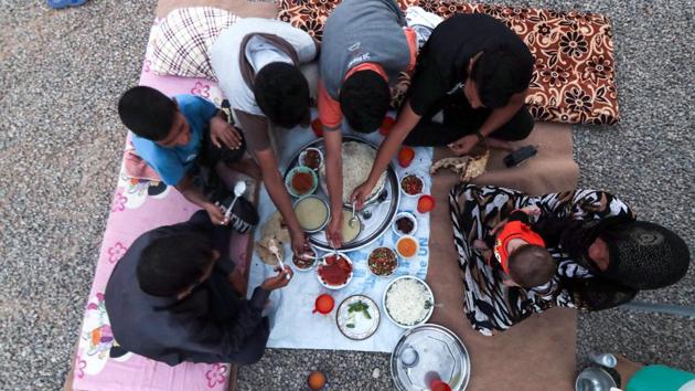 A family breaks fast on the first day of the Muslim holy month of Ramadan, at al-Khazir camp for the internally displaced, located between Arbil and Mosul. (KARIM SAHIB / AFP)