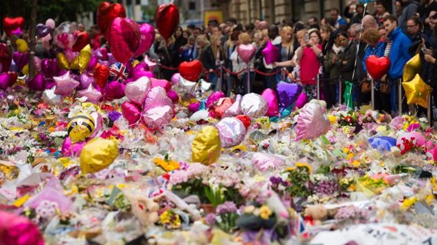 People look at flowers and balloons in St Ann's Square in Manchester on May 29, placed in tribute to the victims of the May 22 terror attack at the Manchester Arena.(AFP Photo)