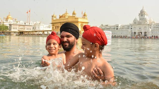 Devotees taking holy dip and paying obeisance at Golden Temple on the occasion of martyrdom anniversary of Sikh Guru Arjan Dev in Amritsar on Monday. (Gurpreet Singh/HT Photo)