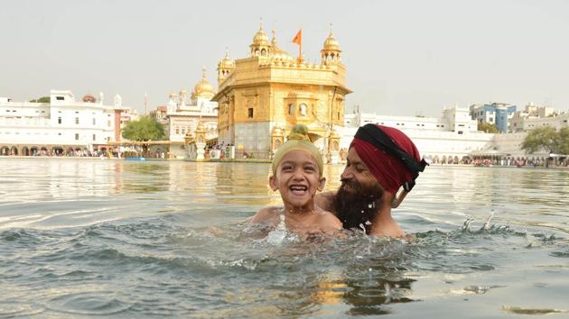 Devotees taking holy dip and paying obeisance at Golden Temple on the occasion of martyrdom anniversary of Sikh Guru Arjan Dev in Amritsar on Monday. (Gurpreet Singh/HT Photo)