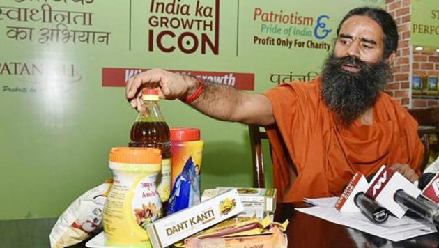 Yoga guru Ramdev shows Patanjali products at a press conference in New Delhi.(HT File Photo)