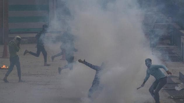 A Kashmiri protester throws an exploded tear gas shell back at police during a protest in Srinagar.(AP file photo)