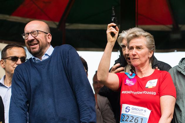 Belgian Prime Minister Charles Michel reacts as Princess Astrid fires a gun to start the Brussels' 20km run on Sunday.(AFP)
