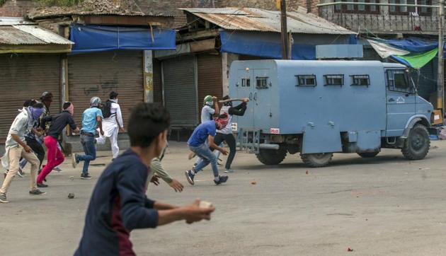 Kashmiri protester throws rocks and bricks at an armoured vehicle belonging to paramilitary solders during a protest in Srinagar, May 26. Ranks of stone-pelters have been joined by children from affluent families. They do it out of conviction, revenge or disdain for the security forces. Not for money.(AP)