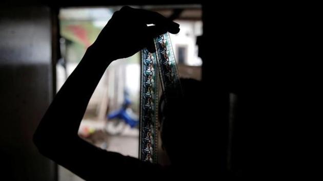 Kamaluddin checks a 35mm film strip at his workshop. Indonesian entrepreneur Kamaluddin loves the gritty look of old 35-millimeter film so much that he spends most of his nights screening vintage movies at weddings and parties around Jakarta (REUTERS)