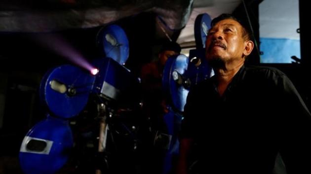 A villager sits next to a projector showing a film, during a circumcision party in Rempoa village on the outskirts of Jakarta. (REUTERS)
