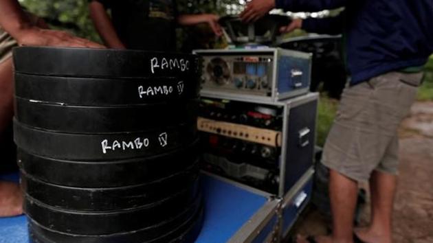 Workers stand next to cans containing copies of the film 'Rambo', before a wedding party. (REUTERS)