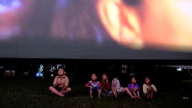 Children sit in a soccer field watching films, during a wedding party in Tangerang. (REUTERS)