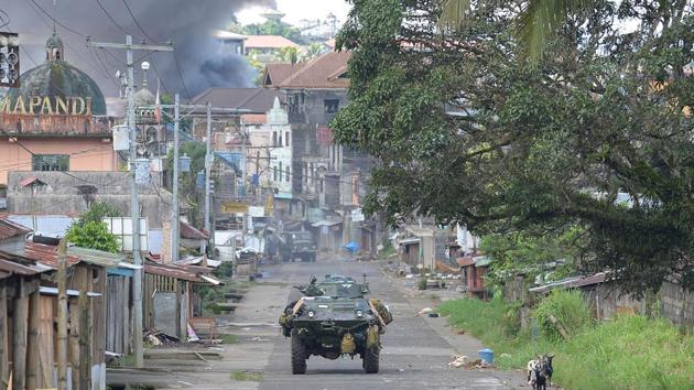 A Philippine Marines armoured personnel carrier speeds away as black smoke billows from burning houses after military helicopters fired rockets at militant positions in Marawi on the southern island of Mindanao. (AFP Photo) A Philippine Marines armoured personnel carrier speeds away as black smoke billows from burning houses after military helicopters fired rockets at militant positions in Marawi on the southern island of Mindanao. (AFP Photo)