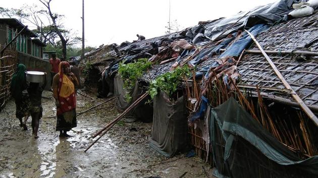 Rohingya refugees walk next to huts in a makeshift camp in Bangladesh's Cox's Bazar district on May 30, 2017 after Cyclone Mora made landfall in the region. (AFP Photo) Rohingya refugees walk next to huts in a makeshift camp in Bangladesh's Cox's Bazar district on May 30, 2017 after Cyclone Mora made landfall in the region. (AFP Photo)