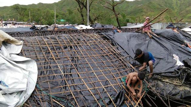 Rohingya refugee children fix the damaged roof of a hut in a makeshift camp in Bangladesh's Cox's Bazar district after Cyclone Mora made landfall in the region.(AFP Photo) Rohingya refugee children fix the damaged roof of a hut in a makeshift camp in Bangladesh's Cox's Bazar district after Cyclone Mora made landfall in the region.(AFP Photo)