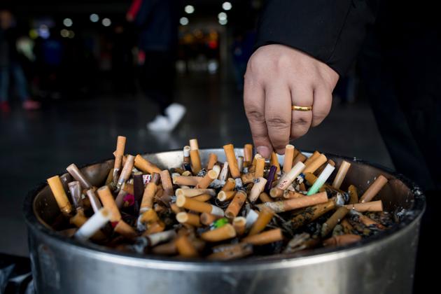 A man grinding out his cigarette in an ashtray at a railway station in Shanghai. Smoking-related diseases claim 7 millions of lives each year in the world, the World Health Organization reported on May 30, 2017, calling to increase taxes on tobacco. (JOHANNES EISELE / AFP) A man grinding out his cigarette in an ashtray at a railway station in Shanghai. Smoking-related diseases claim 7 millions of lives each year in the world, the World Health Organization reported on May 30, 2017, calling to increase taxes on tobacco. (JOHANNES EISELE / AFP)