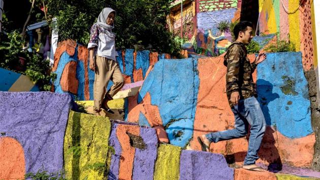 Villagers walking along a path at an Indonesian hamlet . After the makeover there has a huge rush of visitors to the village. (SURYO WIBOWO / AFP) Villagers walking along a path at an Indonesian hamlet . After the makeover there has a huge rush of visitors to the village. (SURYO WIBOWO / AFP)