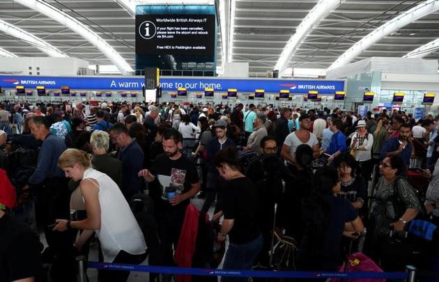 People wait with their luggage at the British Airways check in desks at Heathrow Airport’s Terminal 5 on Sunday.(Reuters)