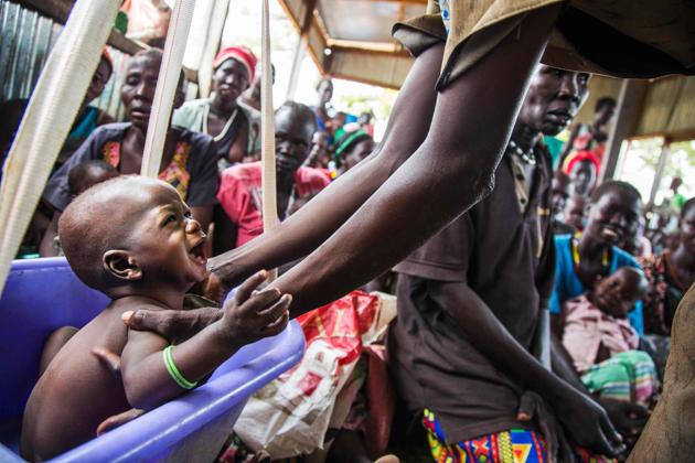 A mother weights her malnourished child in a nutrition centre run by the International Rescue Committee (IRC) in Panthau, Northern Bahr al Ghazal, South Sudan. (Albert Gonzalez Farran / AFP) 