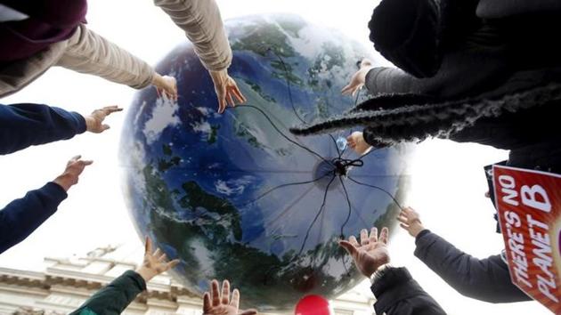 Protesters throw up a globe-shaped balloon during a rally held the day before the start of the 2015 Paris World Climate Change Conference, known as the COP21 summit, in Rome, Italy.(Reuters)