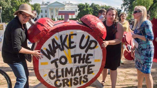 Protesters hold up signs during a demonstration in front of the White House in Washington, DC, objecting to US President Donald Trump's decision to withdraw from the Paris Climate accord.(AFP Photo) Protesters hold up signs during a demonstration in front of the White House in Washington, DC, objecting to US President Donald Trump's decision to withdraw from the Paris Climate accord.(AFP Photo)