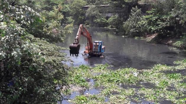 An excavator clearing water hyacinth from the Mithi river on Saturday. (HT Photo) An excavator clearing water hyacinth from the Mithi river on Saturday. (HT Photo)