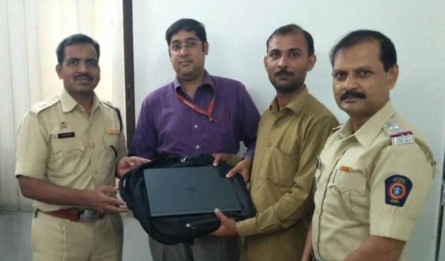 Ashutosh Shukla returns the bag to its rightful owner, Jagannath Ramnan, at Govandi police station on Saturday. (HT photo) Ashutosh Shukla returns the bag to its rightful owner, Jagannath Ramnan, at Govandi police station on Saturday. (HT photo)