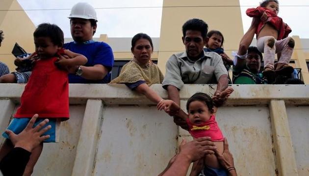 Rescuers and residents carry children down from a truck after they were rescued from their homes, as government troops continue their assault on insurgents from the so-called Maute group, who have taken over large parts of the city, in Papandayan village, Marawi City, Philippines. (Reuters) Rescuers and residents carry children down from a truck after they were rescued from their homes, as government troops continue their assault on insurgents from the so-called Maute group, who have taken over large parts of the city, in Papandayan village, Marawi City, Philippines. (Reuters)