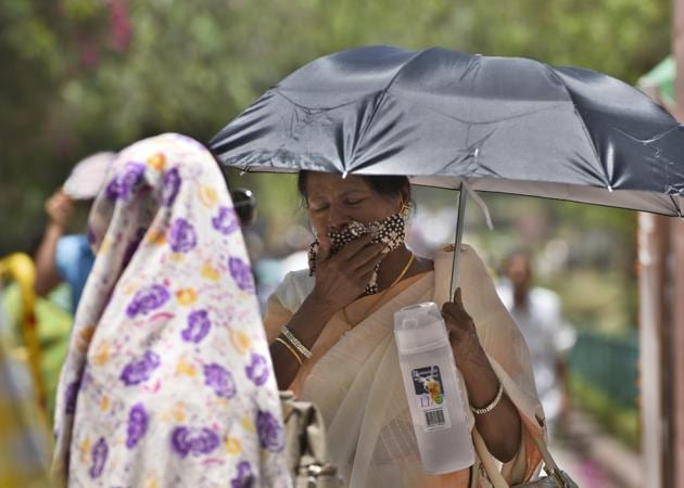 People use scarves and umbrella to save themselves from scorching heat near Raj Ghat as Delhi recorded a highest temperature of 44 degrees Celsius on Sunday (Sushil Kumar/HT PHOTO) People use scarves and umbrella to save themselves from scorching heat near Raj Ghat as Delhi recorded a highest temperature of 44 degrees Celsius on Sunday (Sushil Kumar/HT PHOTO)
