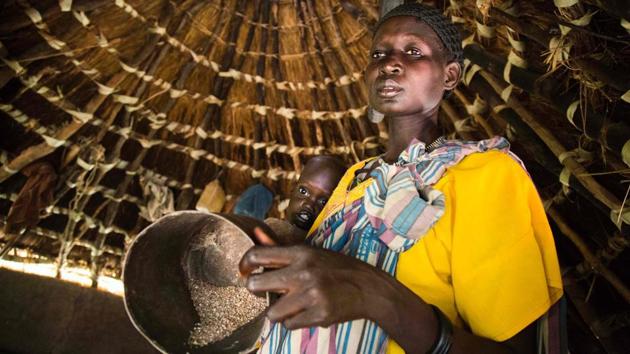 Achol Ayut holds her malnourished child Nyibol Lual, 2.5 years old, and a pot with the only stock of sorghum for her five children, at her house in Panthau, Northern Bahr al Ghazal, South Sudan. Achol usually begs food to relatives and neighbours to feed her family.An estimated 63 per cent of the population in Northern Bahr al Ghazal is experiencing severe food insecurity, according to the latest Integrated Food Security Phase Classification (IPC) report. The situation is particularly bad in Aweil West and Aweil South counties, where the exhaustion of household food stocks and growing dependence on financially inaccessible markets have left the population facing Emergency levels of food insecurity. (Albert Gonzalez Farran / AFP) Achol Ayut holds her malnourished child Nyibol Lual, 2.5 years old, and a pot with the only stock of sorghum for her five children, at her house in Panthau, Northern Bahr al Ghazal, South Sudan. Achol usually begs food to relatives and neighbours to feed her family.An estimated 63 per cent of the population in Northern Bahr al Ghazal is experiencing severe food insecurity, according to the latest Integrated Food Security Phase Classification (IPC) report. The situation is particularly bad in Aweil West and Aweil South counties, where the exhaustion of household food stocks and growing dependence on financially inaccessible markets have left the population facing Emergency levels of food insecurity. (Albert Gonzalez Farran / AFP)