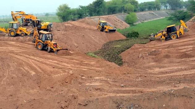 Farmers of Jhansla village in Patiala district levelling the SYL canal with the help of earthmoving machines in March 2016, after the Punjab assembly passed a bill providing for transfer of proprietary rights to the original owners.(HT File Photo)