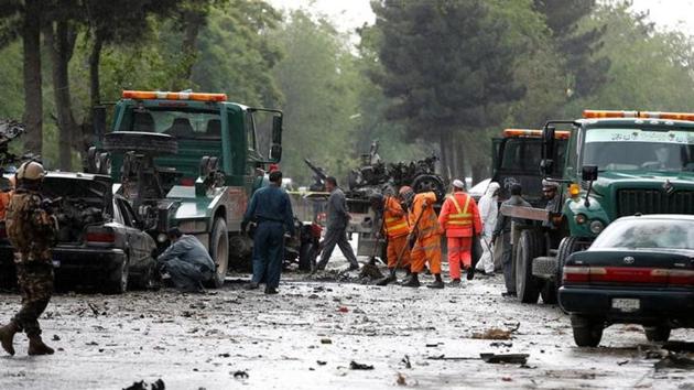 Afghan police and municipal workers clear debris from the site of a suicide bomb attack in Kabul. (Reuters)
