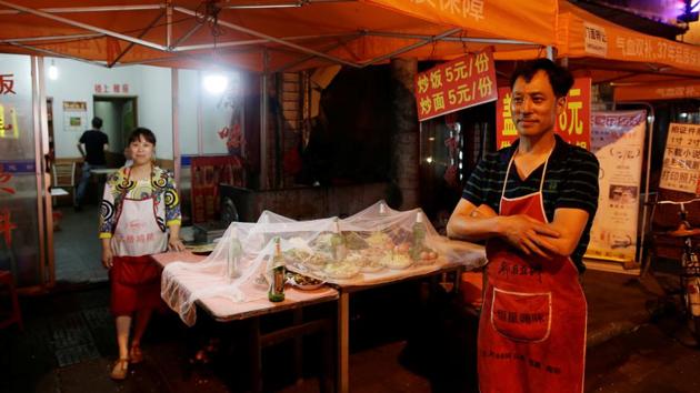 Restaurant owner Zhang Xunze and his wife Xie Yingchun pose for a photograph by their restaurant. They moved to the town three years ago so that their son could attend the Motanchang Middle School. (Jason Lee/REUTERS) Restaurant owner Zhang Xunze and his wife Xie Yingchun pose for a photograph by their restaurant. They moved to the town three years ago so that their son could attend the Motanchang Middle School. (Jason Lee/REUTERS)