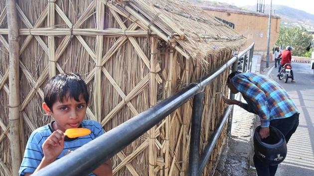 Seven year old Payal eats an orange candy while a thirsty passerby drinks from a piyao. (HimanSHU VYAS / HT PHOTO) Seven year old Payal eats an orange candy while a thirsty passerby drinks from a piyao. (HimanSHU VYAS / HT PHOTO)