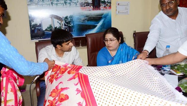 Officials examine a saree that’s likely to be gifted to women by the Telangana government on the occasion of Bathukamma. (HT photo) Officials examine a saree that’s likely to be gifted to women by the Telangana government on the occasion of Bathukamma. (HT photo)
