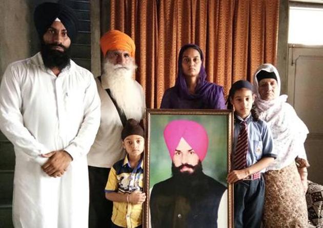 Victim Sukhraj Singh’s family with his portrait in Tarn Taran. They plan to move the HC for capital punishment to the accused.(HT Photo)
