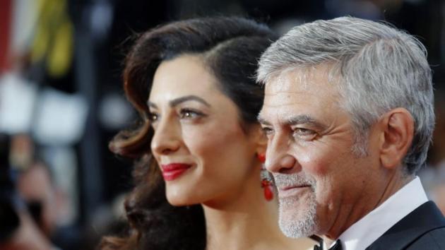 George Clooney and his wife Amal pose on the red carpet for the screening of the film Money Monster out of competition at the 69th Cannes Film Festival.
