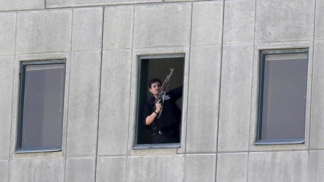 An armed man stands at a window of the parliament building in Tehran on June 7, 2017. Several attackers stormed Iran's parliament and a suicide bomber targeted the shrine of Ayatollah Ruhollah Khomeini killing a security guard and wounding several others. The Islamic State so far has claimed responsibility for attack at Iranian parliament. (AP)