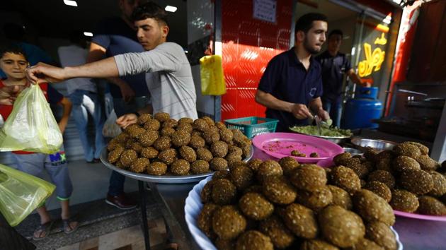 A Palestinian street vendor sells falafel at his stall during Ramadan in Gaza City. Savoury snacks are popular choices for breaking the fast at sunset throughout the Middle-East. (AFP) A Palestinian street vendor sells falafel at his stall during Ramadan in Gaza City. Savoury snacks are popular choices for breaking the fast at sunset throughout the Middle-East. (AFP)