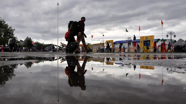 Tourists take a stroll in the cloudy weather after heavy rain at Ridge, Shimla. (Deepak Sansta / HT Photo)