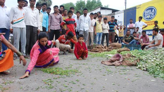 Villagers gather vegetables dumped on the road by farmers during a protest in Aurangabad, Maharashtra in June. Farmers in the state have so far rejected Chief Minister Devendra Fadnavis’s offer for a waiver by October and rejected the plan for making sales below the support price illegal, demanding expedited resolution. (ht photos)