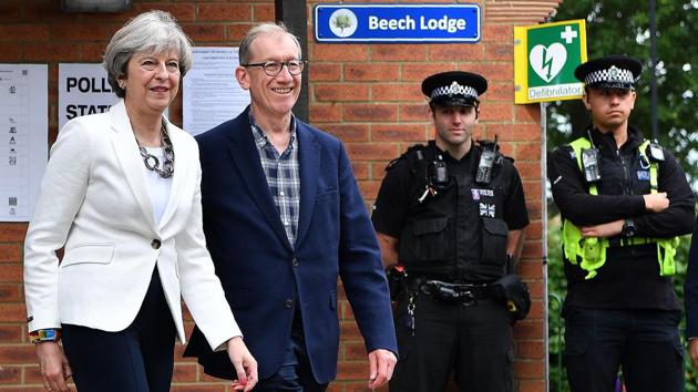 Police officers stand on duty as Britain's Prime Minister Theresa May and her husband Philip, leave a Polling Station after casting their ballot papers in Sonning, west of London. Voting started in Britain on Thursday for the snap general election called by Prime Minister Theresa May in April. May announced the election in hopes of increasing the Conservative Party’s slim majority in parliament, and strengthening her hand in European Union exit talks. (Ben STANSALL / AFP) Police officers stand on duty as Britain's Prime Minister Theresa May and her husband Philip, leave a Polling Station after casting their ballot papers in Sonning, west of London. Voting started in Britain on Thursday for the snap general election called by Prime Minister Theresa May in April. May announced the election in hopes of increasing the Conservative Party’s slim majority in parliament, and strengthening her hand in European Union exit talks. (Ben STANSALL / AFP)
