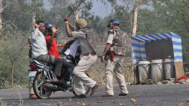 Police cane commuters on the Mhow- Neemuch highway in Mandsaur. (Mujeeb Faruqui/HT Photo)