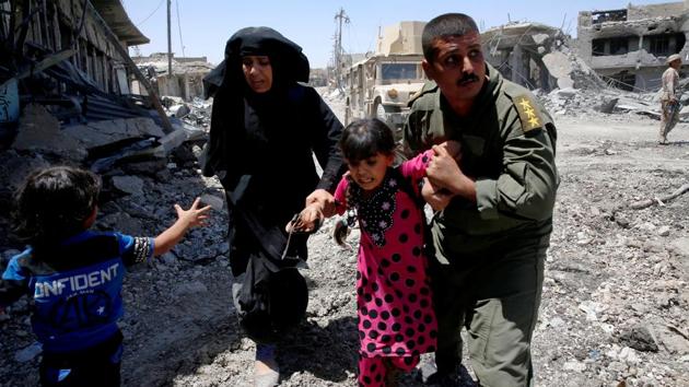 Iraqi soldiers help residents displaced by fighting between Iraqi forces and Islamic State militants in Mosul. (Erik De Castro / Reuters)
