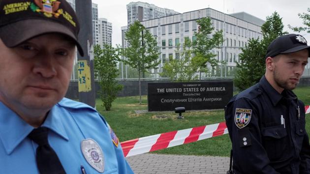 A guard (L) and a police officer are seen in front of the U.S. embassy in Kiev, Ukraine, June 8, 2017.(REUTERS)