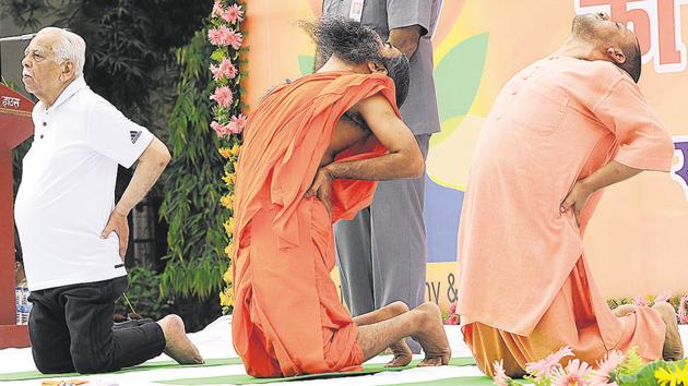 UP Governor Ram Naik, CM Yogi Adityanath practise yoga with Baba Ramdev in a yoga session at Raj Bhawan,Lucknow.(Subhankar Chakraborty/HT Photo)