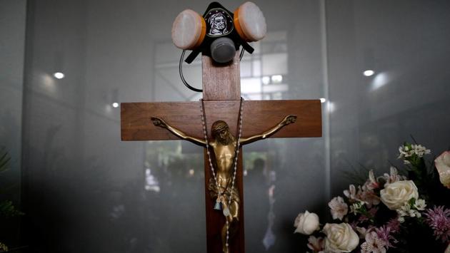 A tear gas mask hangs on a crucifix over a coffin  at the funeral of Neomar Lander.  (Carlos Garcia Rawlins/REUTERS) 