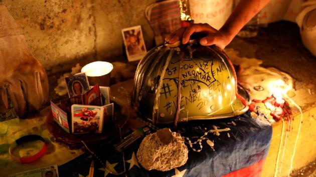 A person holds the helmet of 17-year-old protester Neomar Lander during a candle light march.  (REUTERS) 