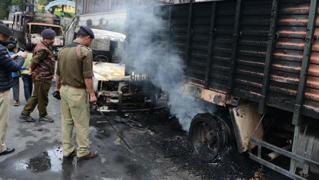 Indian police examine burnt police vehicles after clashes between police and Gorkha People's Liberation Front (GJMM)supporters in Darjeeling. (DIPTENDU DUTTA / AFP) 