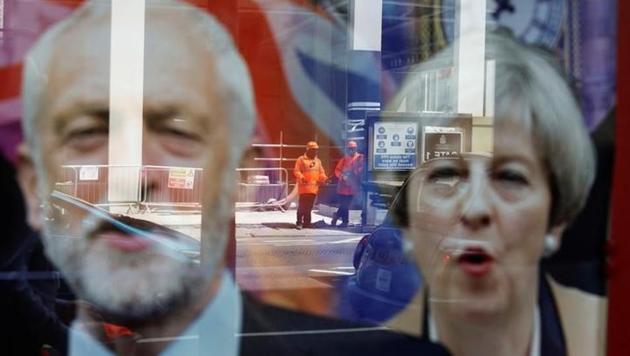 Workers in protective equipment are reflected in the window of a betting shop with a display inviting customers to place bets on the result of the general election with images of Britain's Prime Minister Theresa May and opposition Labour Party leader Jeremy Corbyn, in London. (Reuters Photo) Workers in protective equipment are reflected in the window of a betting shop with a display inviting customers to place bets on the result of the general election with images of Britain's Prime Minister Theresa May and opposition Labour Party leader Jeremy Corbyn, in London. (Reuters Photo)