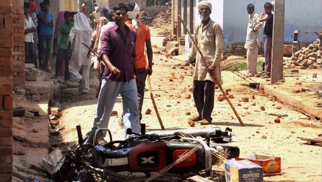 Saharanpur: People near a damaged bike after a clash during a Shobhayatra in Saharanpur on Friday. (PTI) Saharanpur: People near a damaged bike after a clash during a Shobhayatra in Saharanpur on Friday. (PTI)